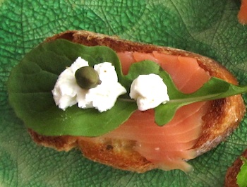 Photo of Bruchetta with smoked salmon, arugula, dabs of goat cheese, and capers / www.super-seafood-recipes.com