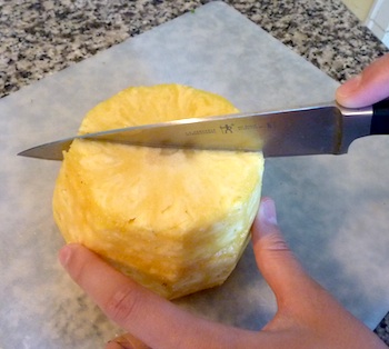Picture of ripe pineapple being cut in half vertically / www.super-seafood-recipes.com